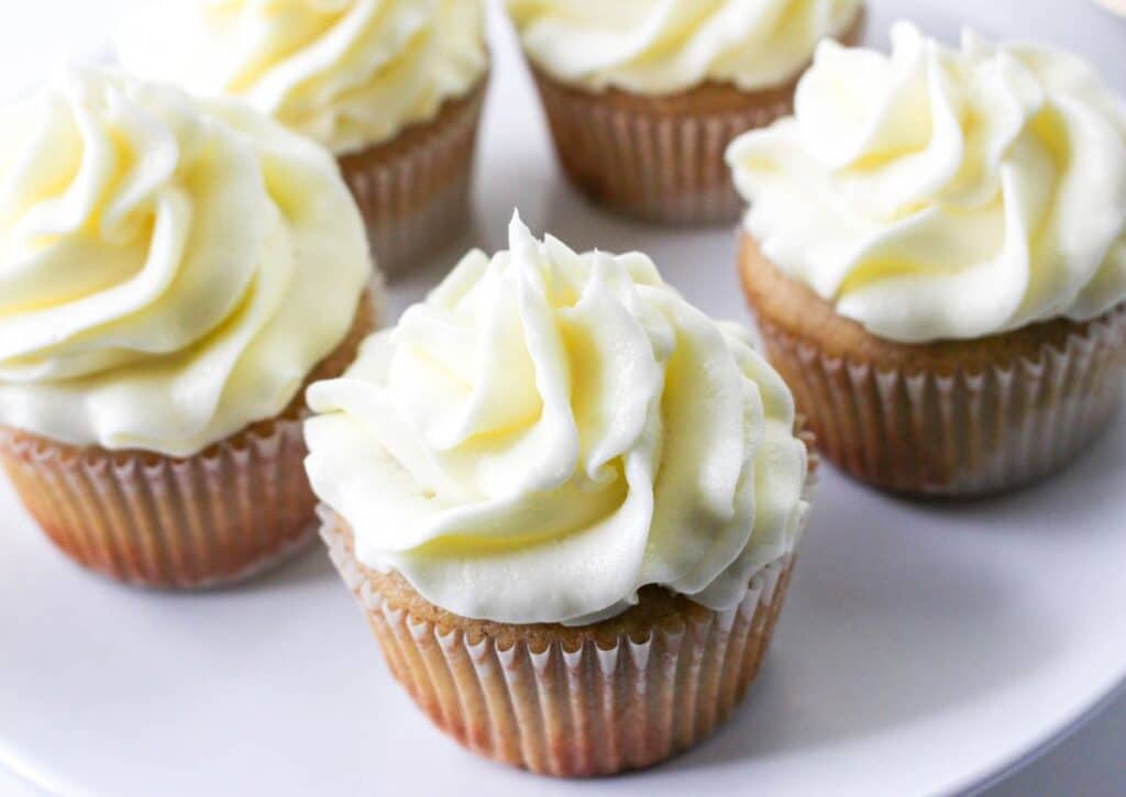 frosted cupcakes on a white plate without the caramel drizzle