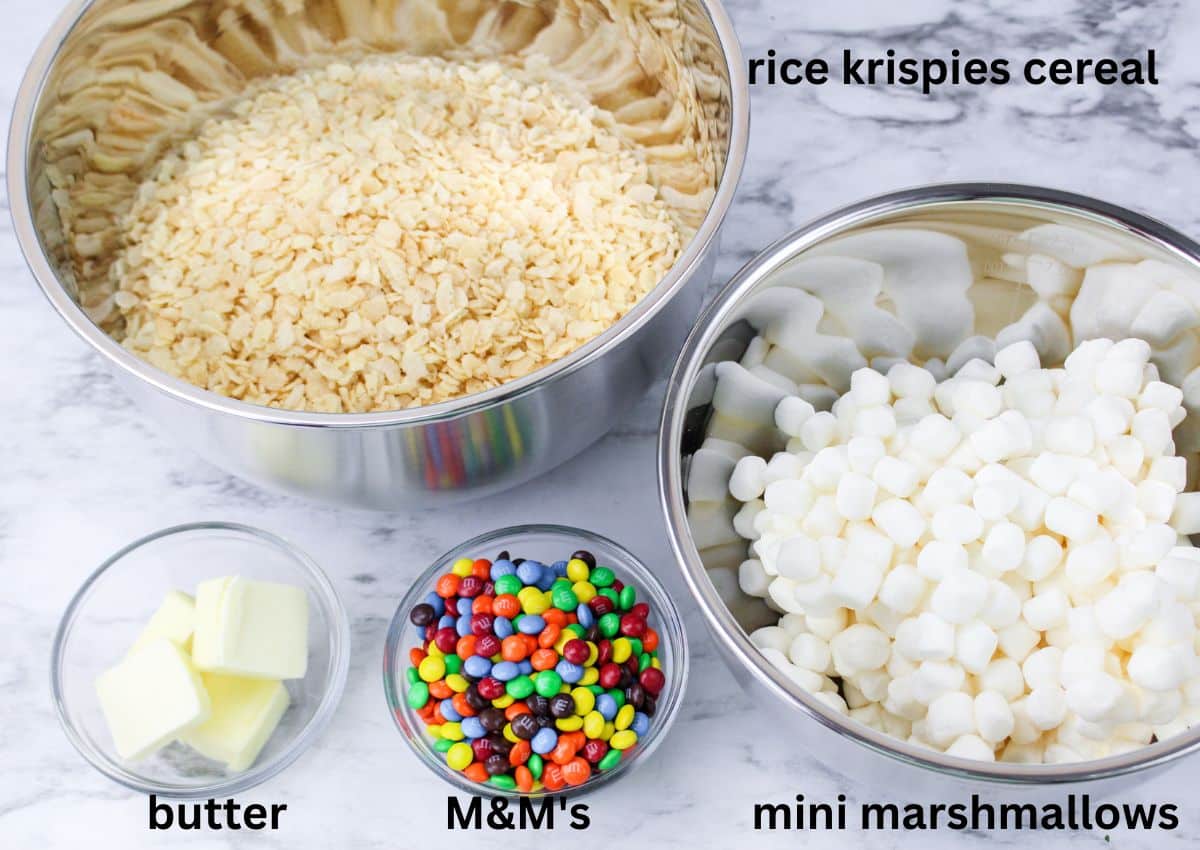 bowls of rice krispies cereal, mini marshmallows, pats of butter, and mini M&M's