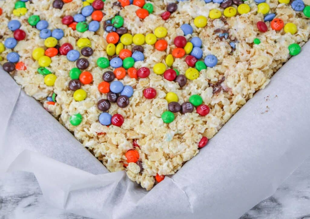 rice Krispie treats cooling in a parchment lined baking dish