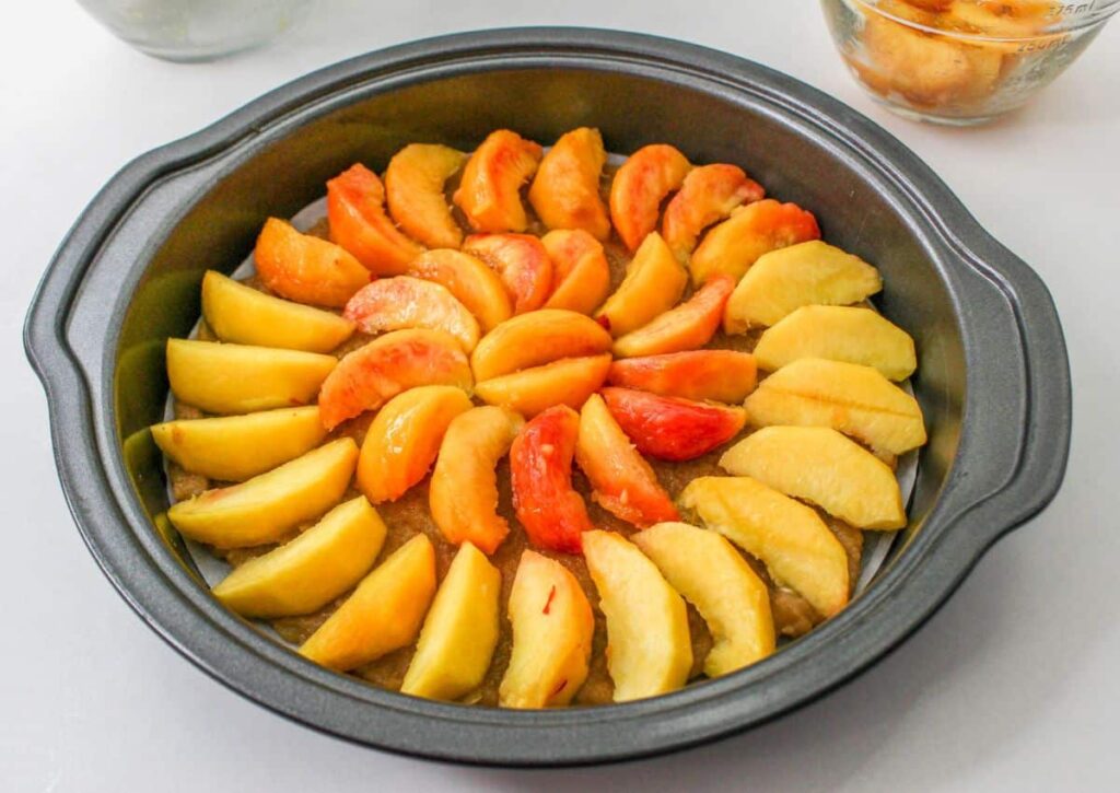 peaches, melted butter and brown sugar in the bottom of the round cake pan