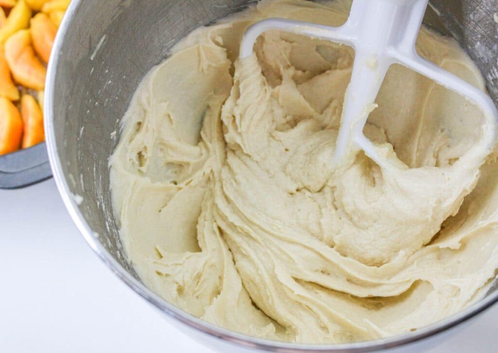cake batter in the bowl of a stand mixer with the paddle attachment