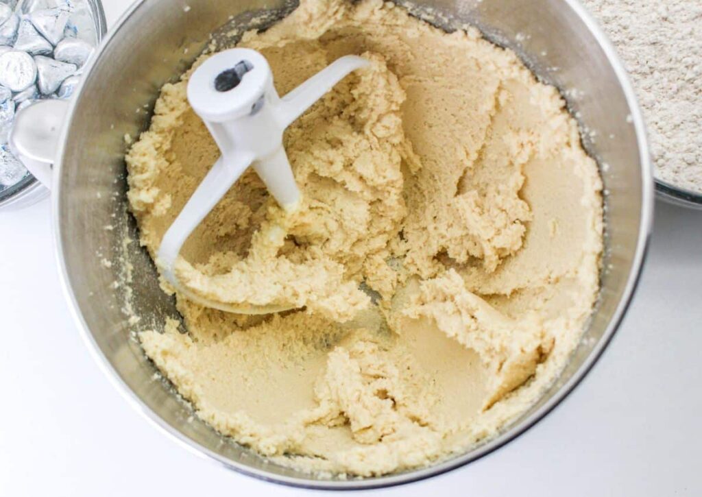 butter, sugar, and brown sugar being creamed in a stand mixer