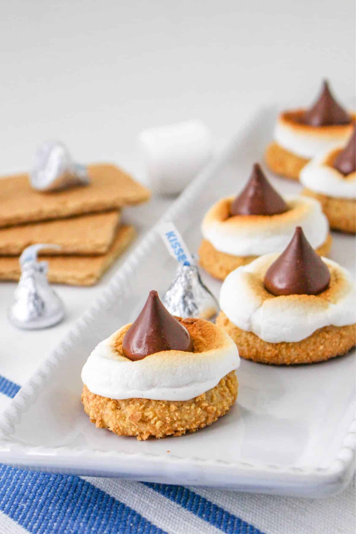 smores blossom cookies on a plate platter on top of a blue and white kitchen towel