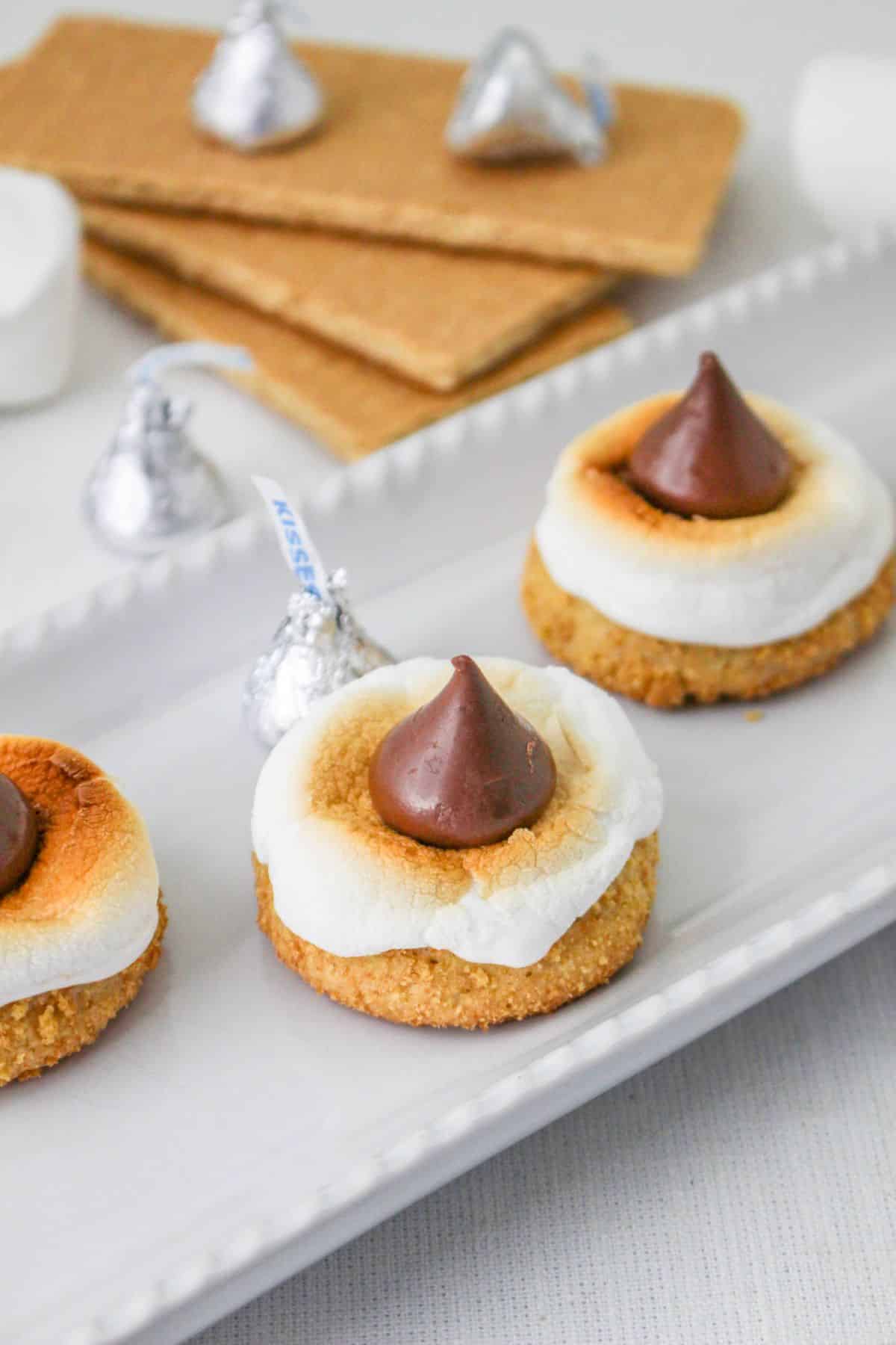 smores blossom cookies on a plate platter with a stack of graham crackers in the background