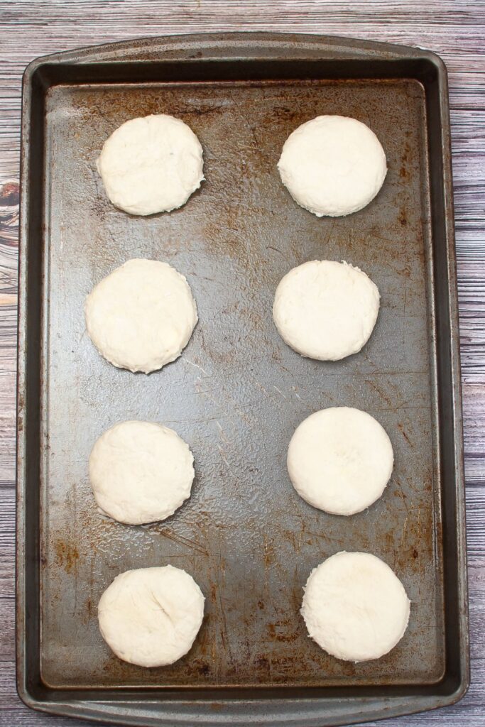 raw biscuits on a dark baking sheet