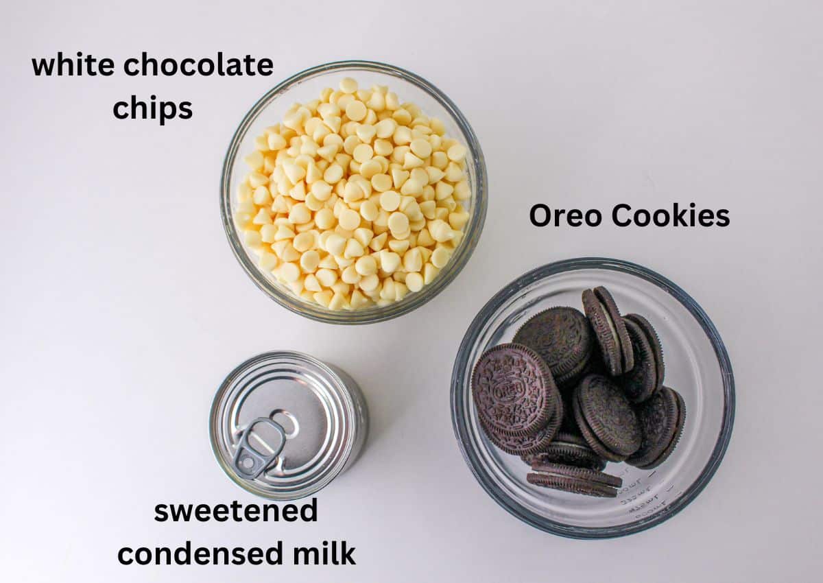 bowls of white chocolate chips and Oreo cookies, and a can of sweetened condensed milk.