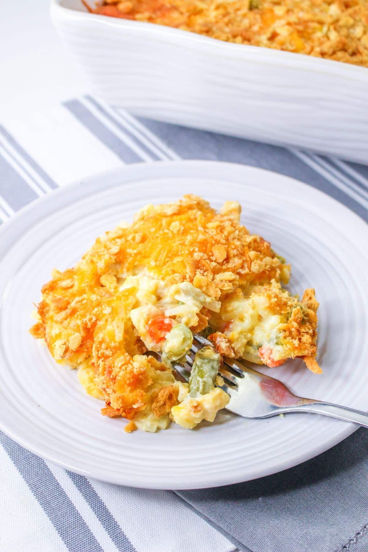 serving of chicken hashbrown casserole on a plate with a bite on a fork