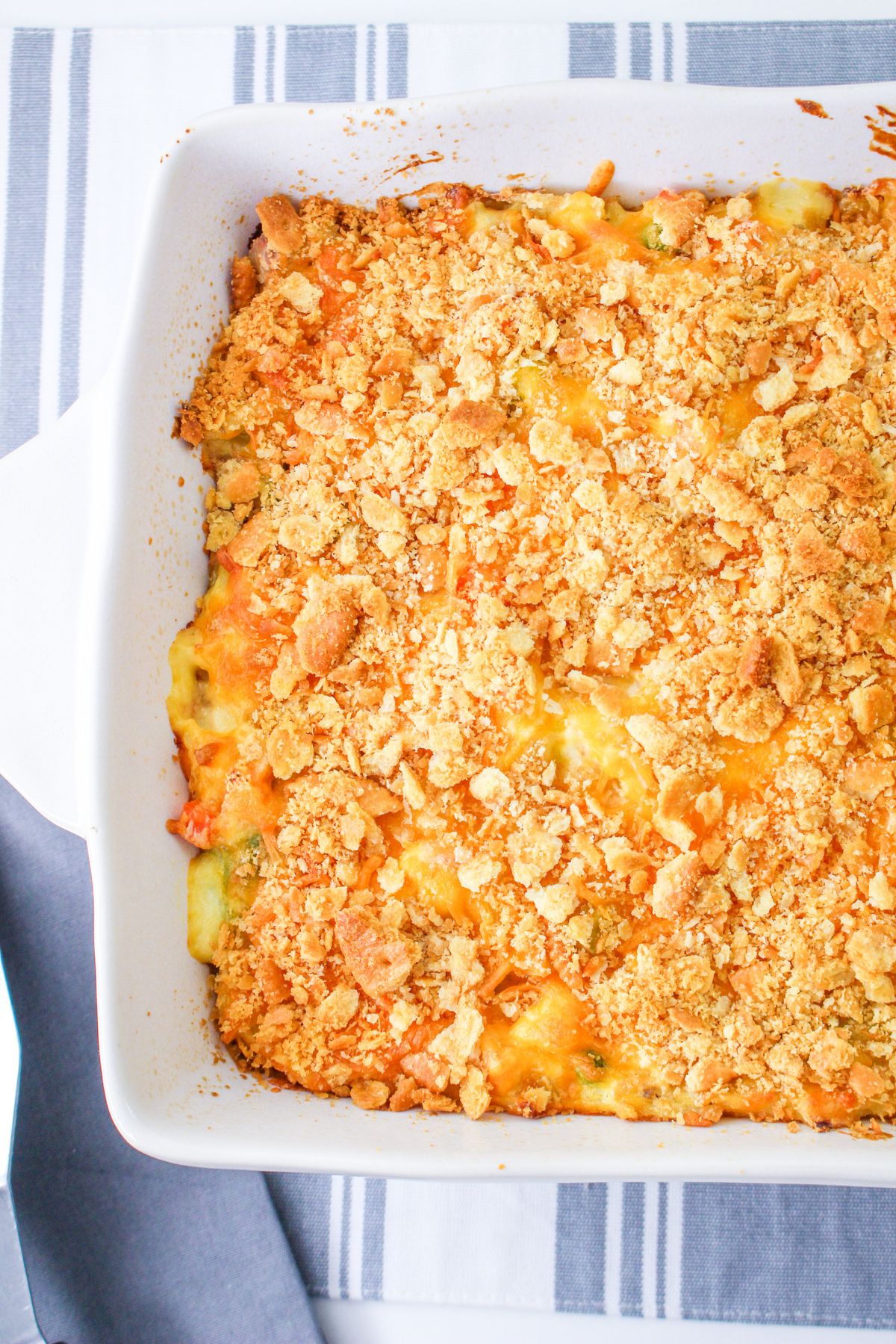 uncut casserole in a baking dish topped with crackers and cheese