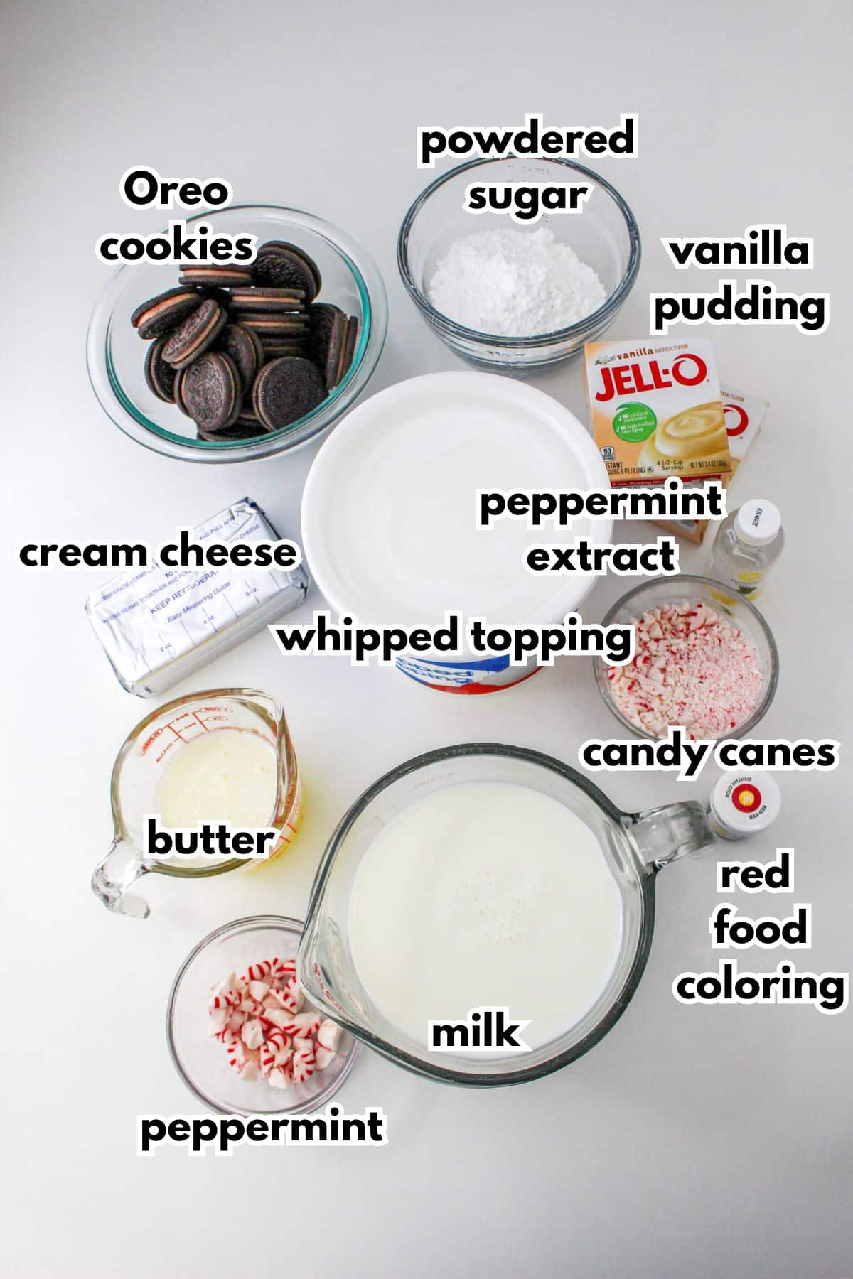 bowls of Oreo cookies, powdered sugar, cream cheese, peppermint extract, vanilla pudding boxes, whipped topping, butter, candy canes, milk, red food coloring and peppermint candies.