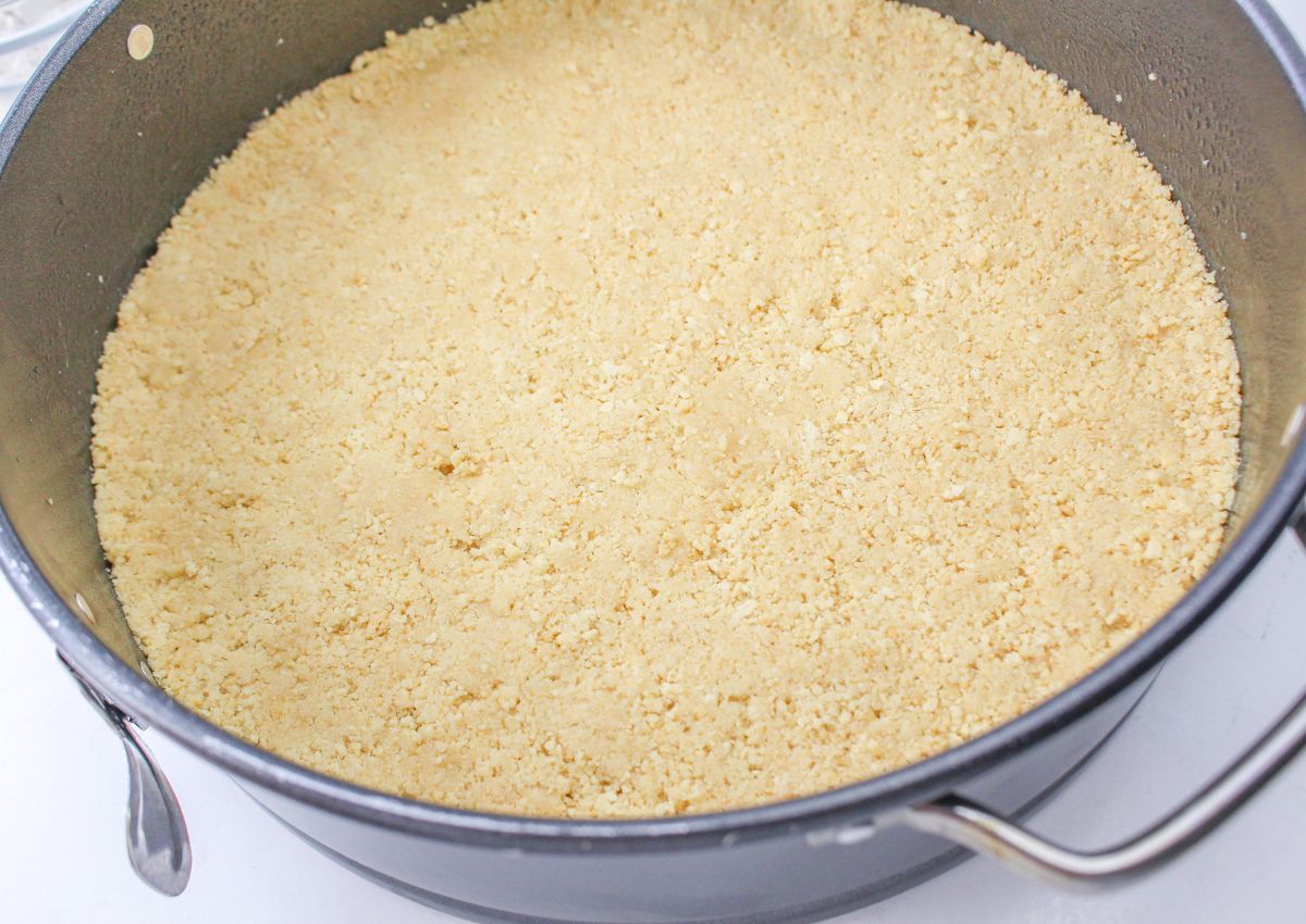 Golden Oreo crust pressed into a springform pan.