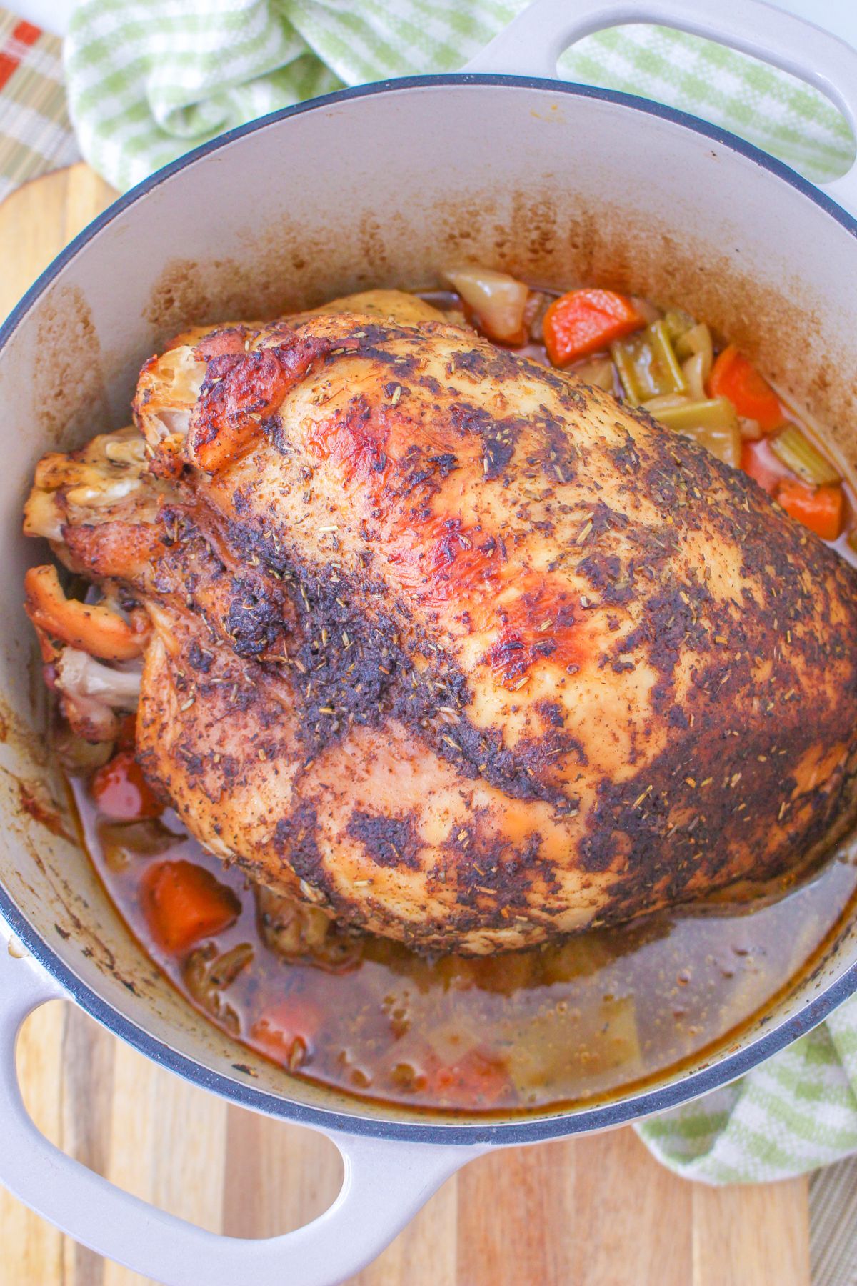 unsliced turkey breast in a dutch oven with vegetables.