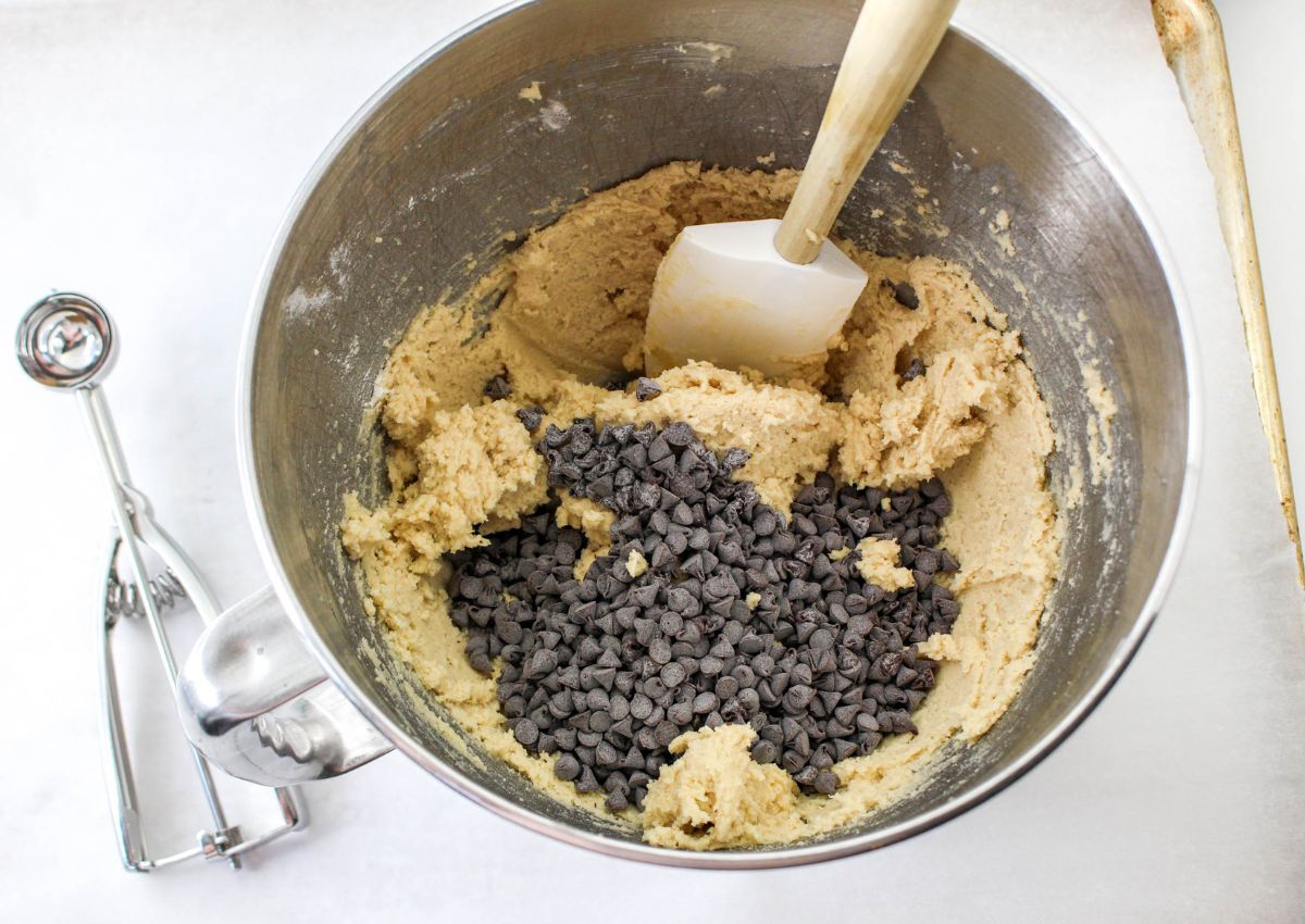 mini chocolate chips being folded into cookie dough.