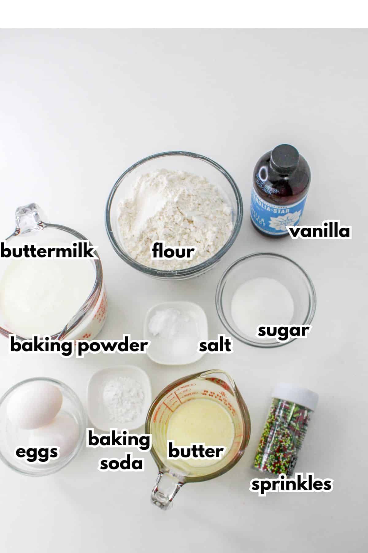 bowls of buttermilk, flour, vanilla extract, baking powder, salt, sugar, eggs, baking soda, butter, and sprinkles.