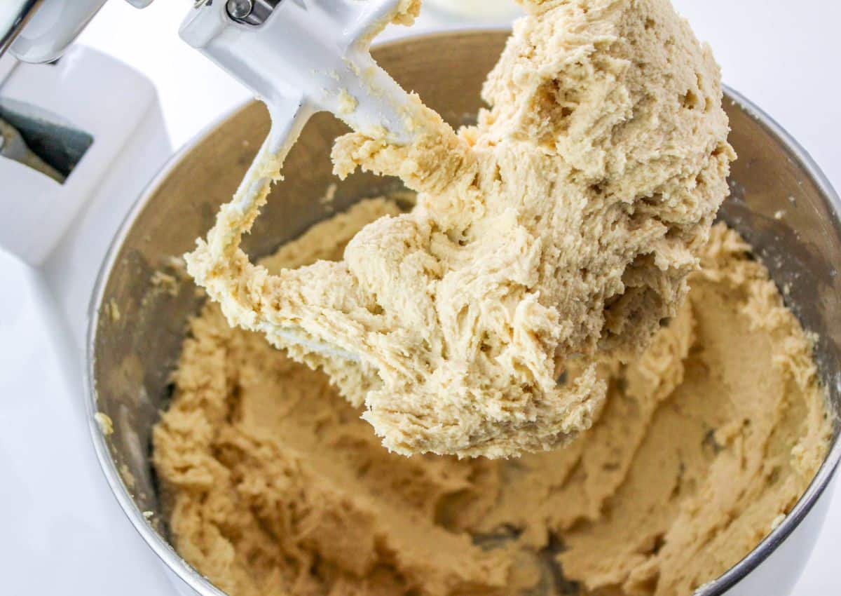 cookie dough being mixed in a stand mixer.