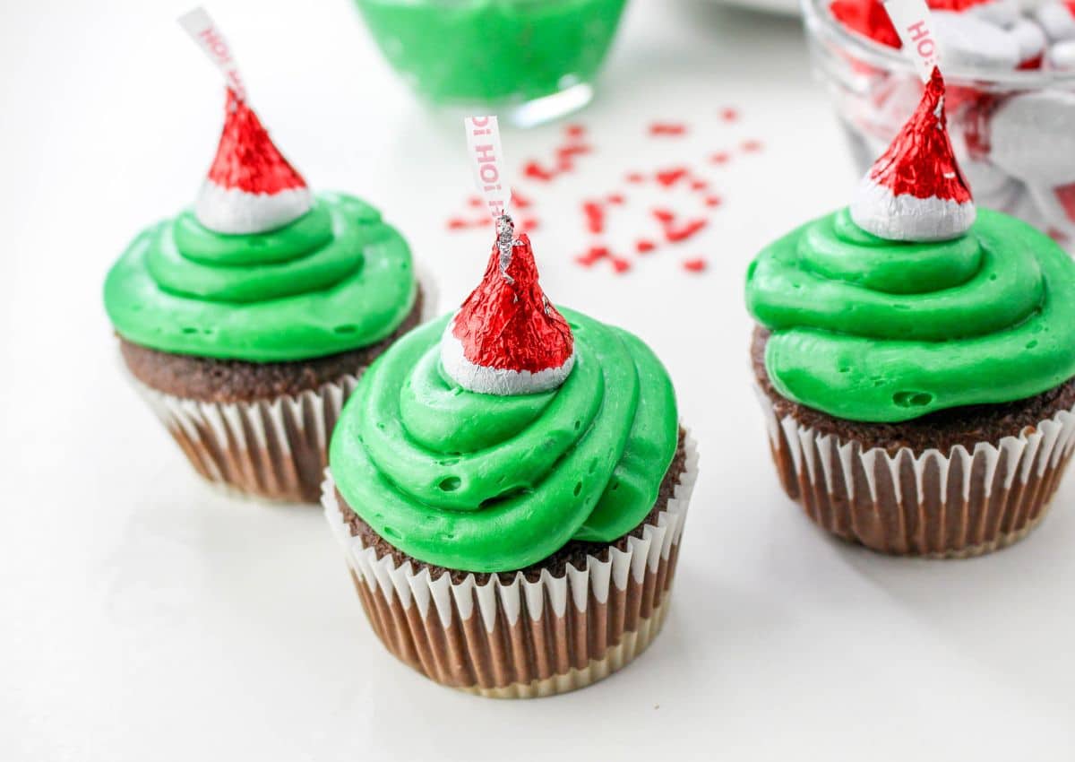 three  grinch cupcakes on a counter.