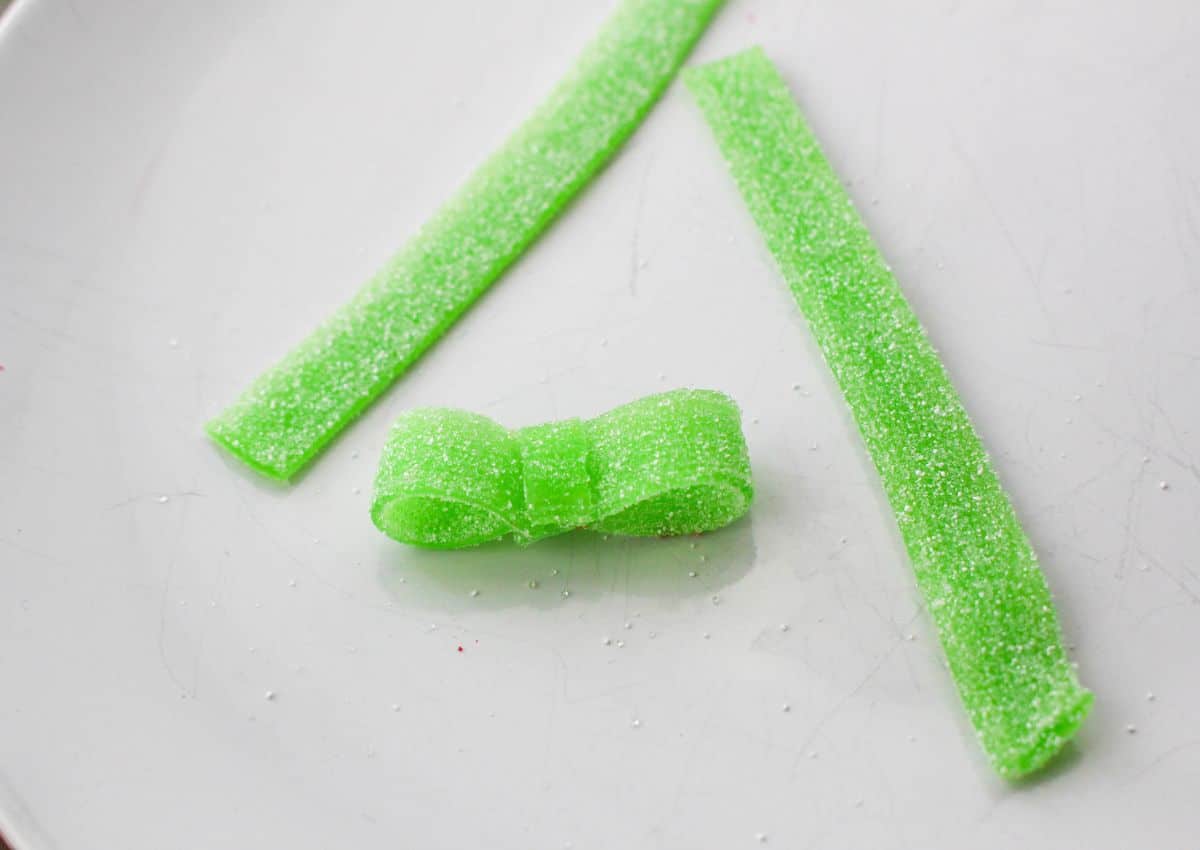 sour streamer candy being cup and shaped into a bow.