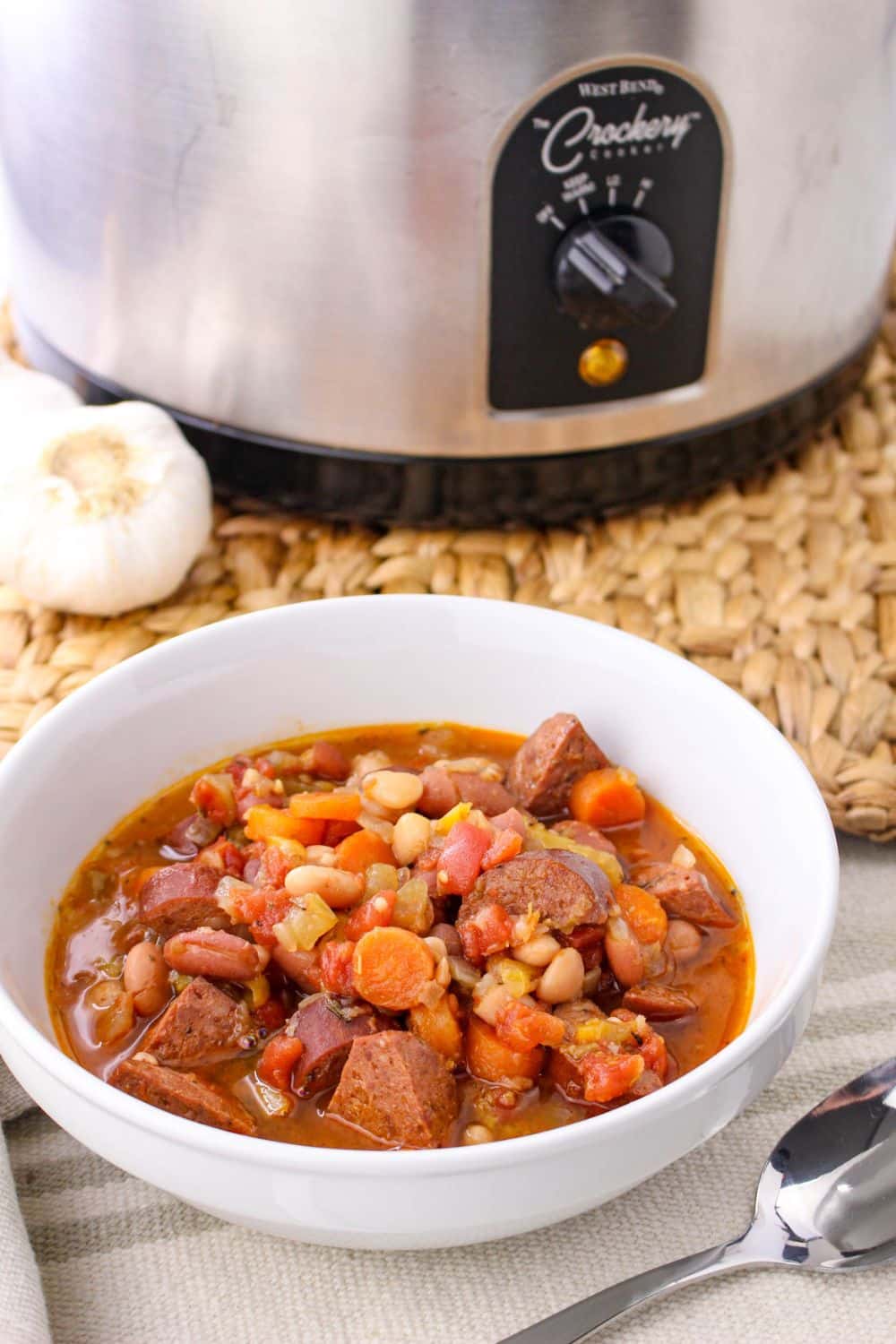 Cajun Bean Soup in a bowl with a slow cooker in the background