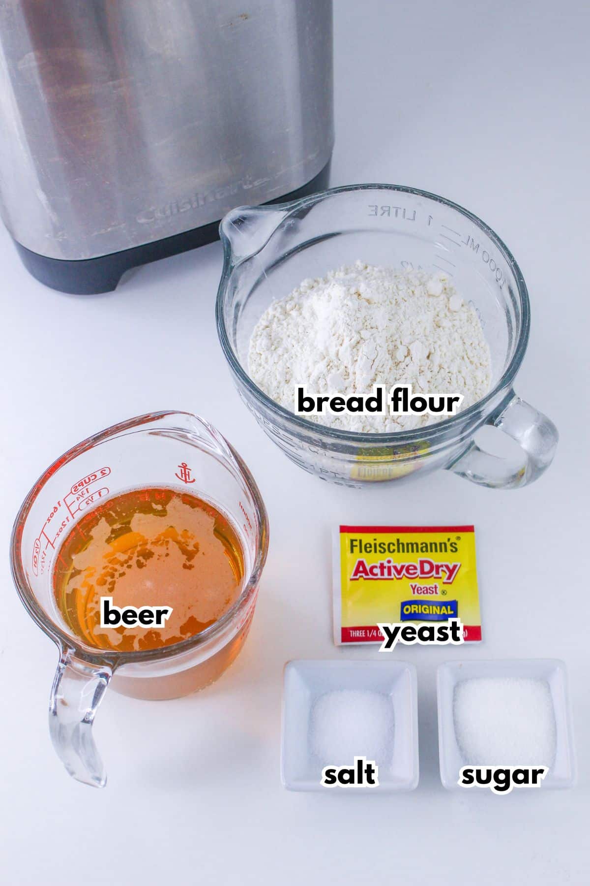 bowls of bread flour, warm beer, a packet of yeast, salt and sugar.