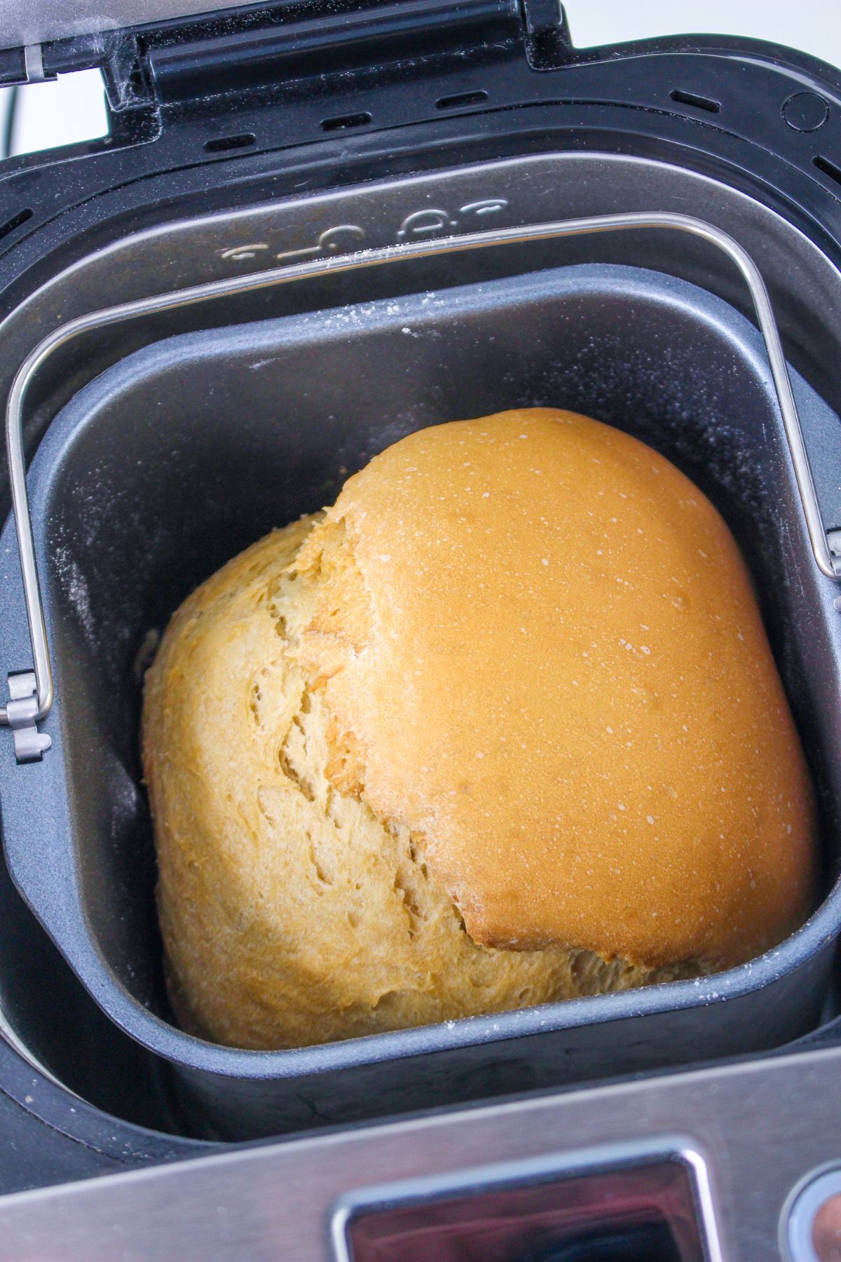 baked bread in the loaf pan of a machine.
