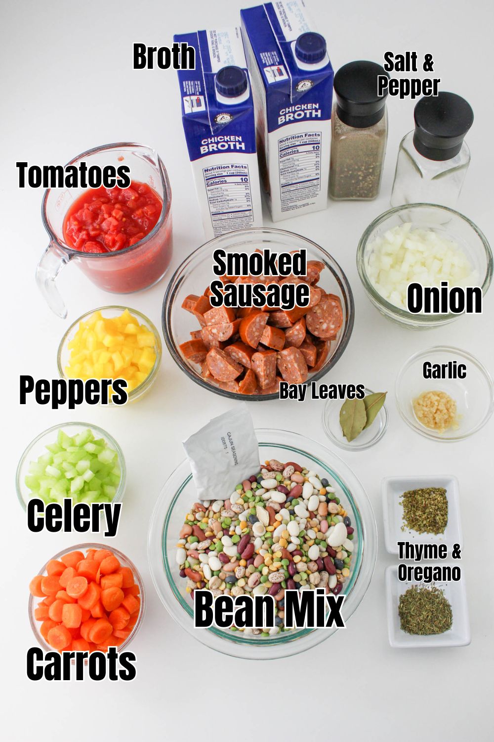 ingredients for cajun bean soup in individual bowls - broth, tomatoes, peppers, oinons, carrots, celery, smoked sausage, beans, spices