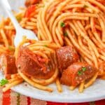 Andouille Sausage Spaghetti on a plate with a fork full of pasta and a piece of sausage
