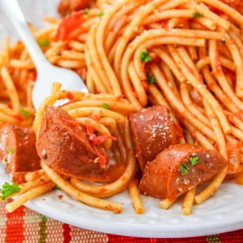 Andouille Sausage Spaghetti on a plate with a fork full of pasta and a piece of sausage