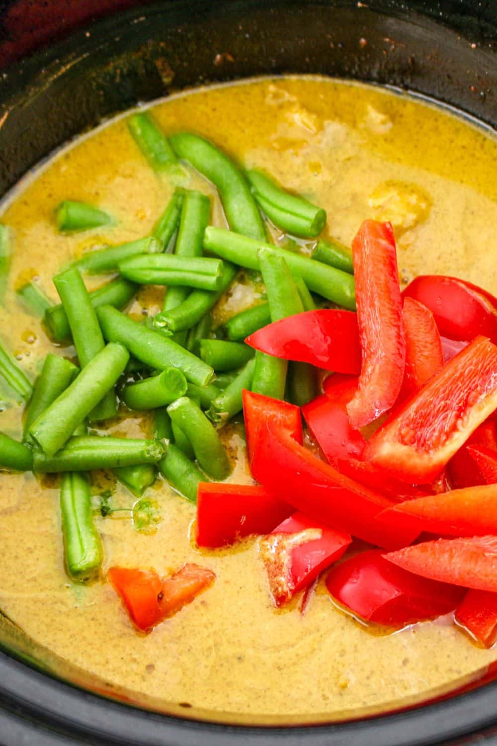 chicken satay with red peppers and green beans on top of the slow cooker mixture