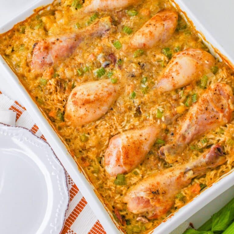 cooked chicken drumsticks on a bed of rice in a casserole dish.