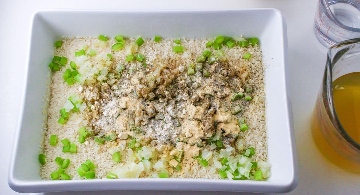 rice, seasoning, celery, and onions in a casserole dish.