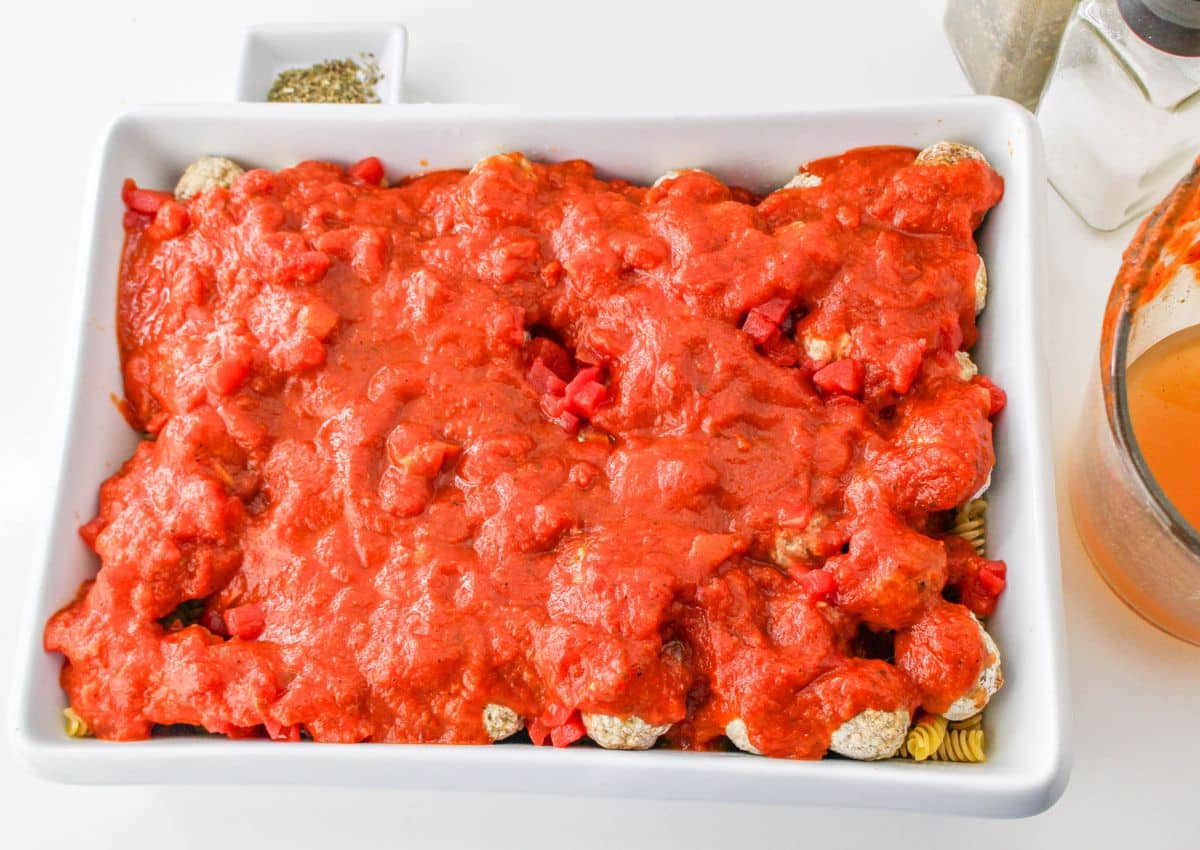pasta sauce poured over the meatballs in casserole dish