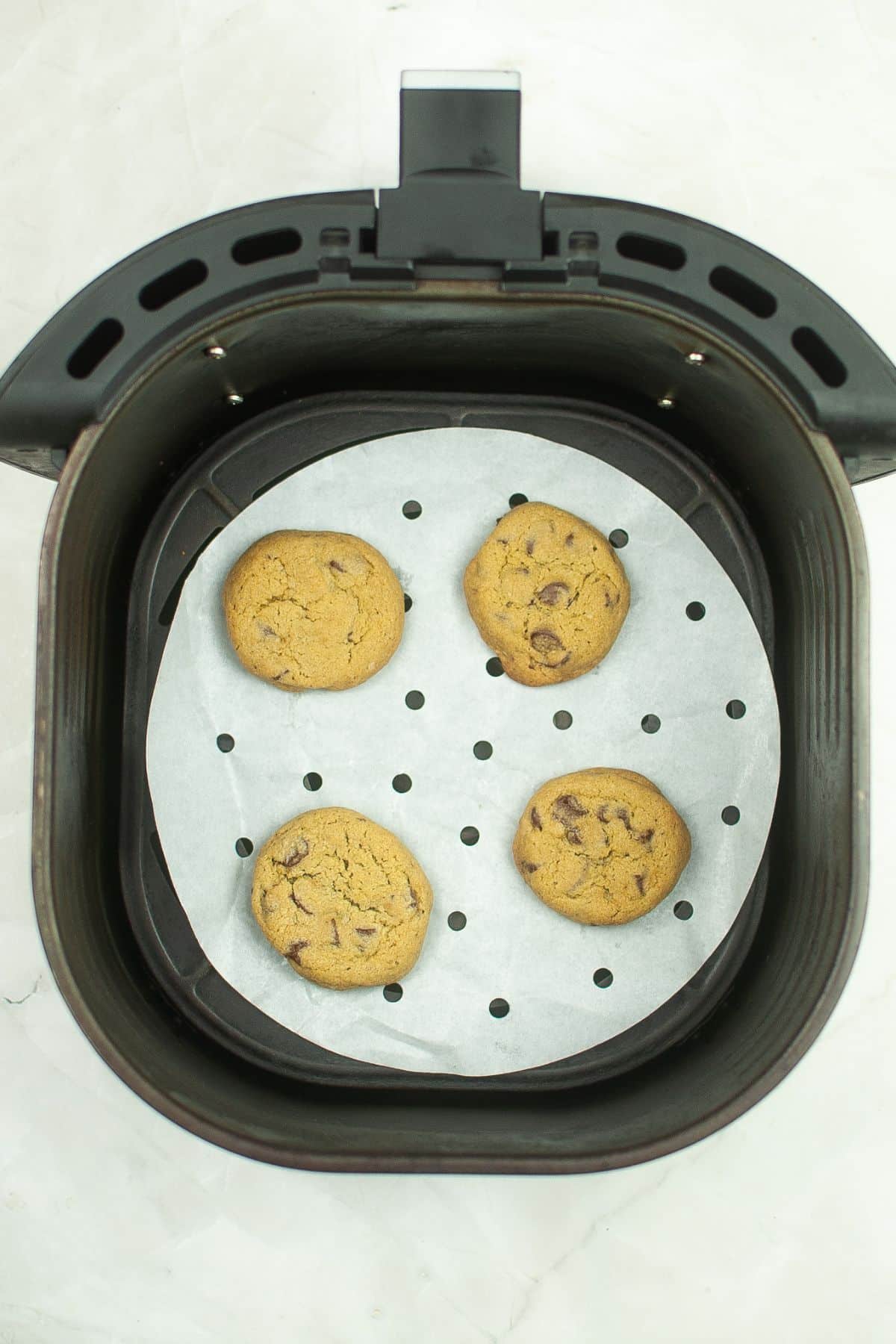 four matcha cookies being cooked in an air fryer.
