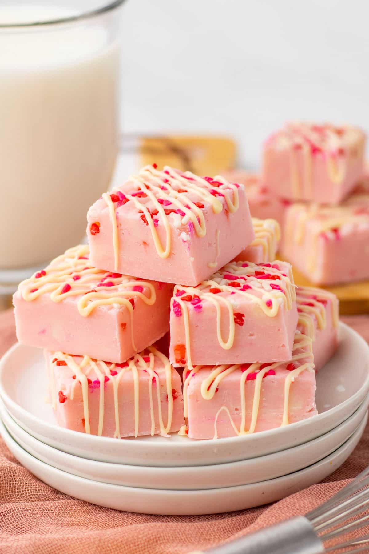 stack of pink sugar cookie fudge on a white plate