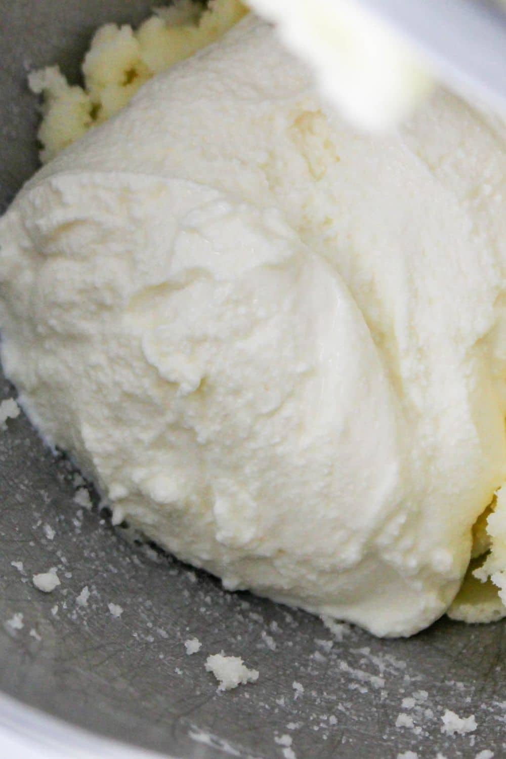 ricotta cheese in a stand mixer with butter mixture already in bowl