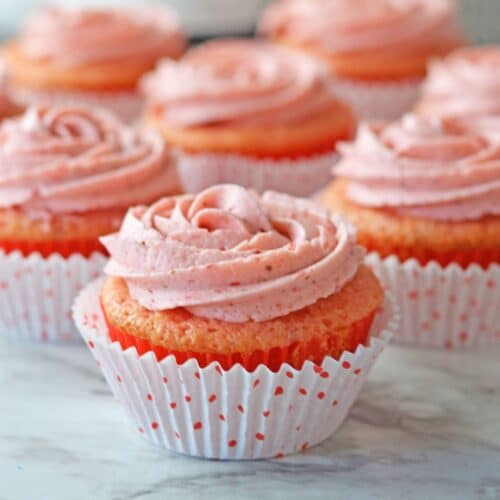 strawberry champagne cupcakes on a marble counter.