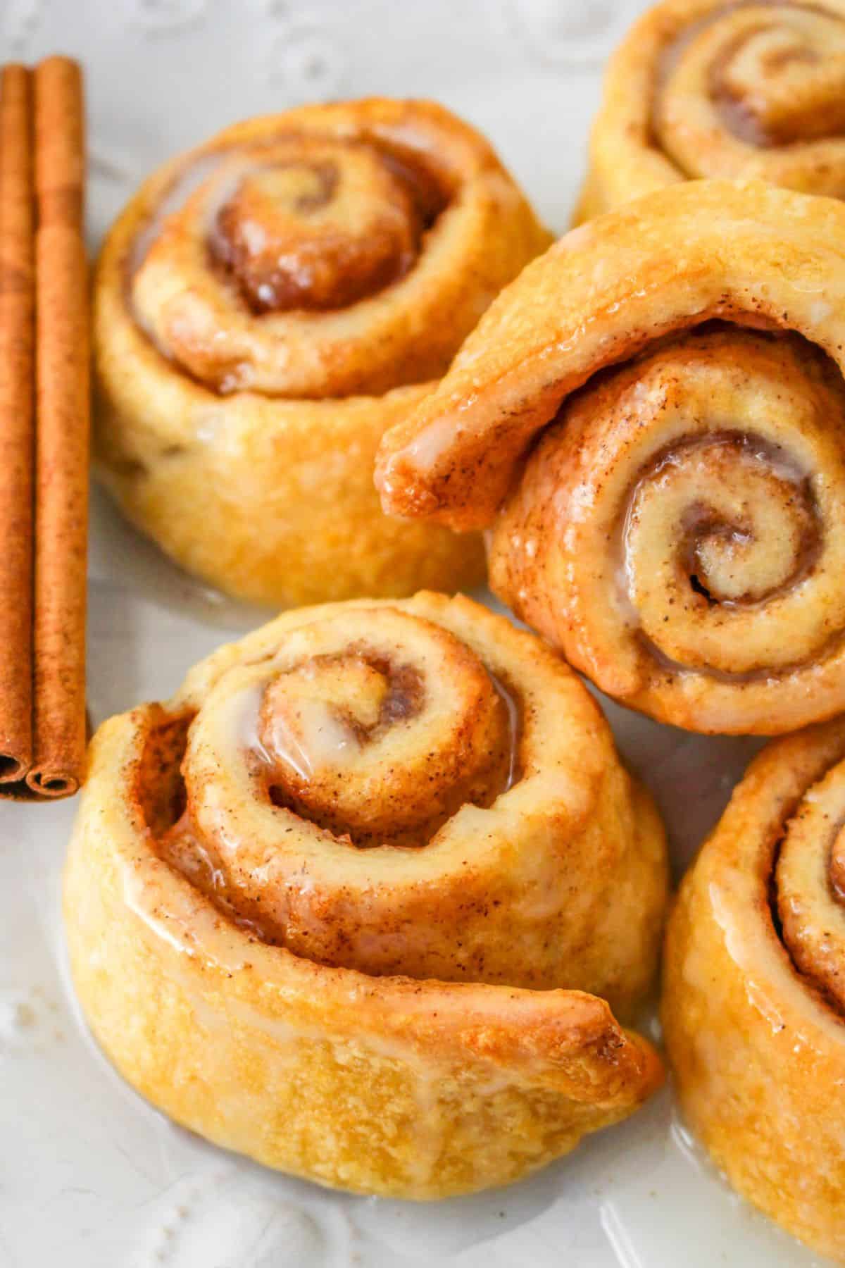 air fryer cinnamon rolls stacked on a plate.