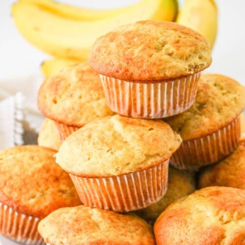 banana cake mix muffins stacked on a plate.