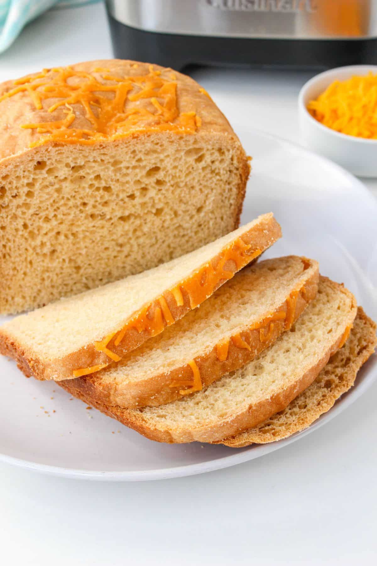loaf of cheese bread on a plate with four slices cut.