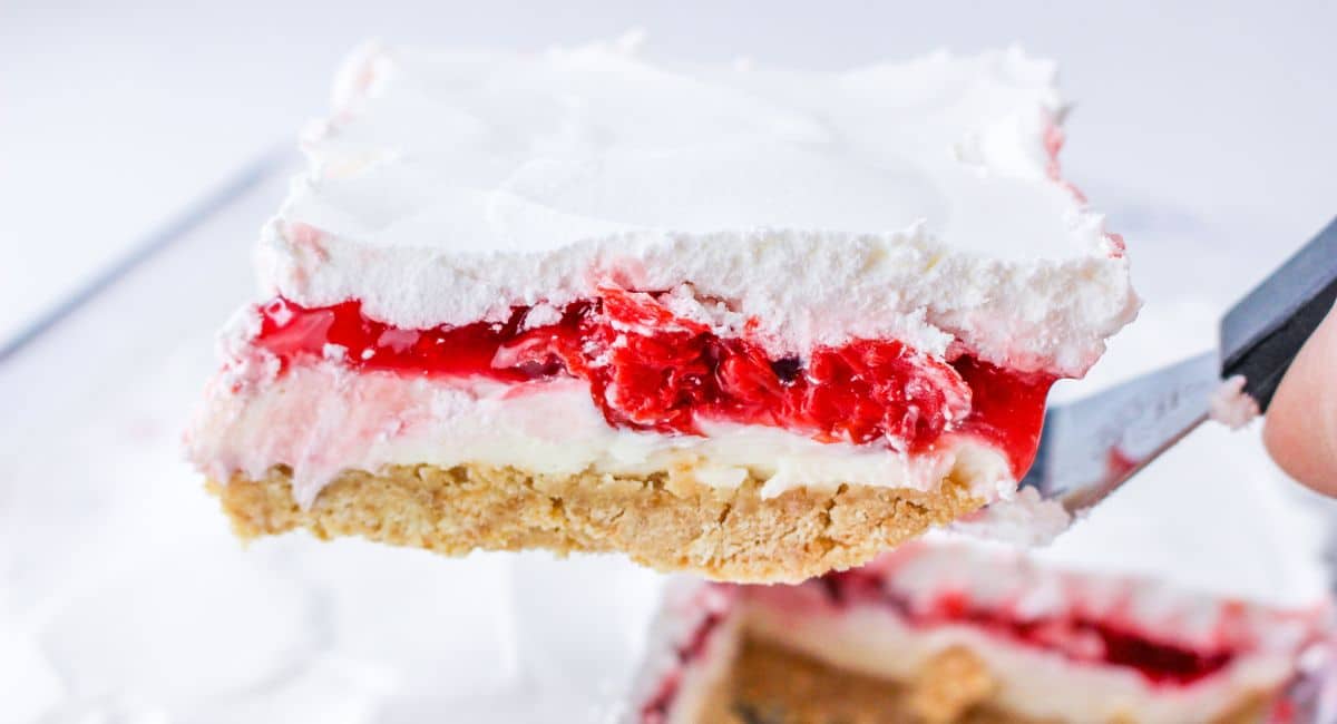 slice of cherry cheesecake lush held on a spatula in the air.