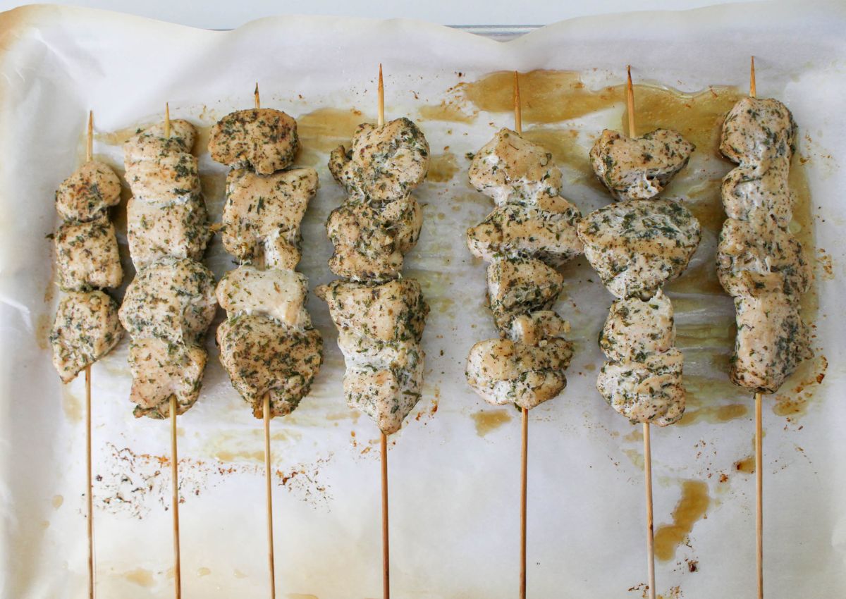 chicken skewers on a parchment lined baking sheet.