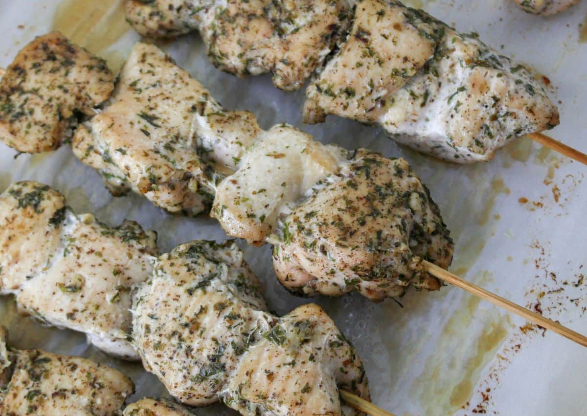 chicken skewers on a parchment lined baking sheet.