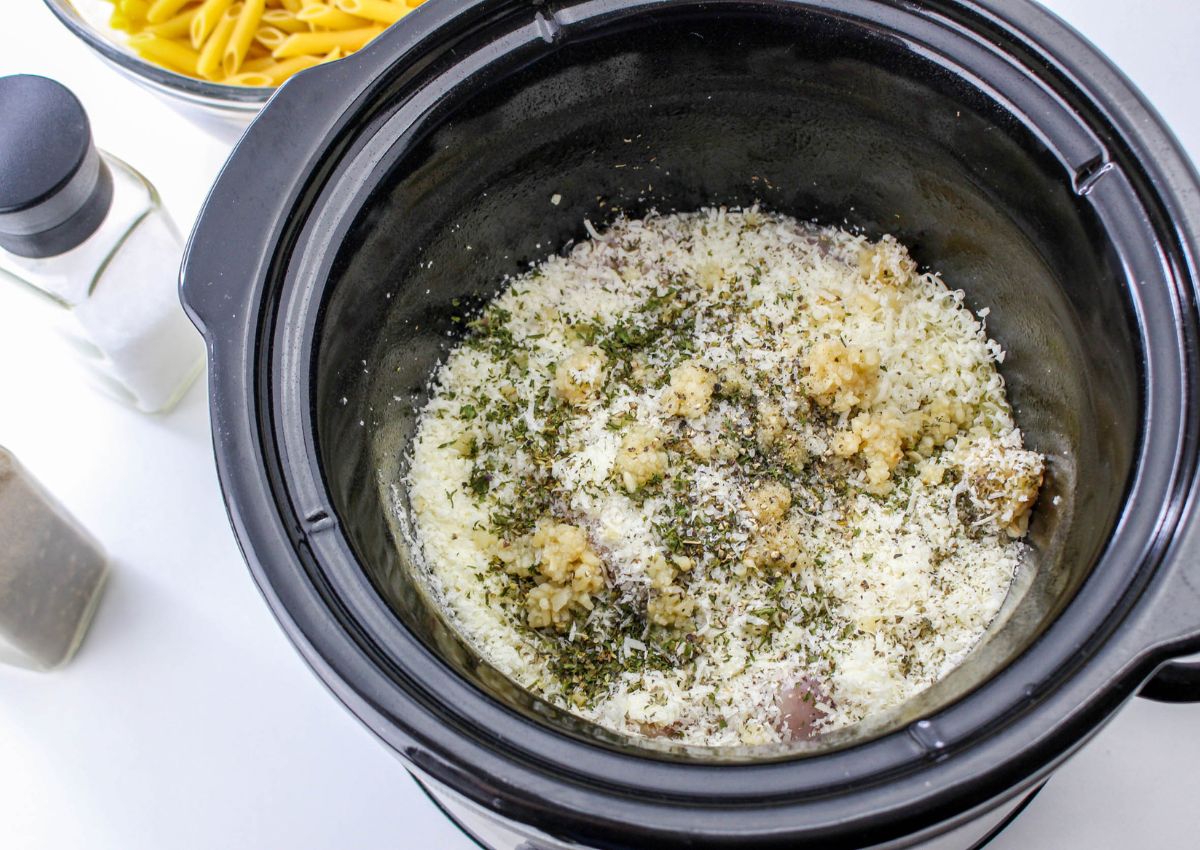 chicken, garlic, seasonings, and broth in a slow cooker.