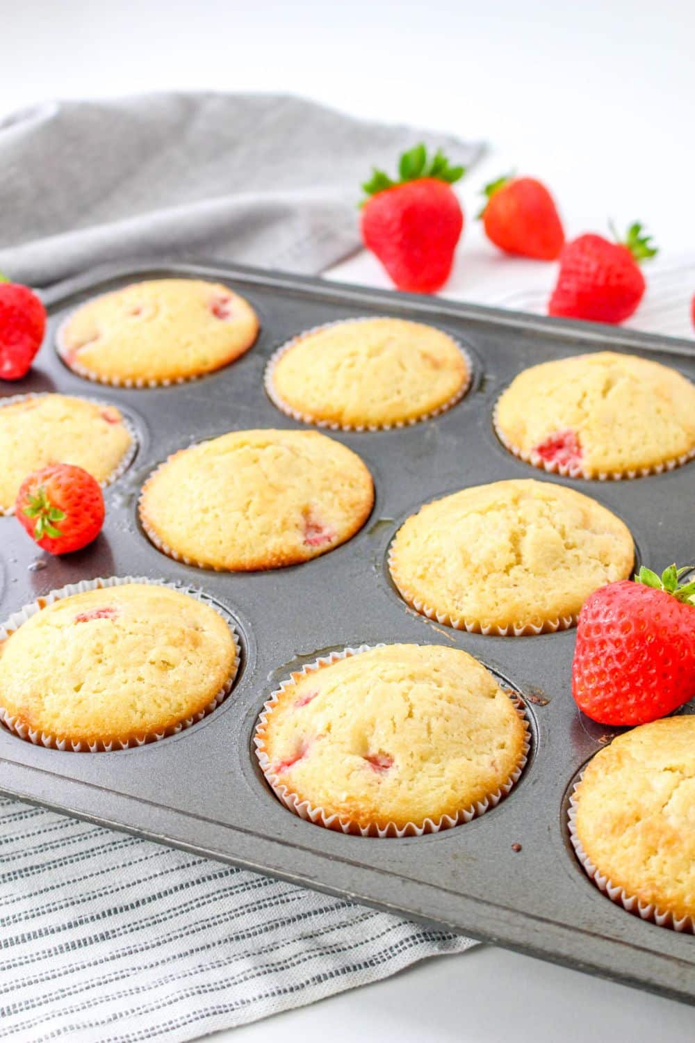 Strawberry White Chocolate Chip Muffins in a muffin tin on top of a cooling rack