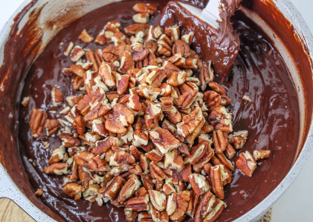 chopped pecans being stirred into the fudge batter.