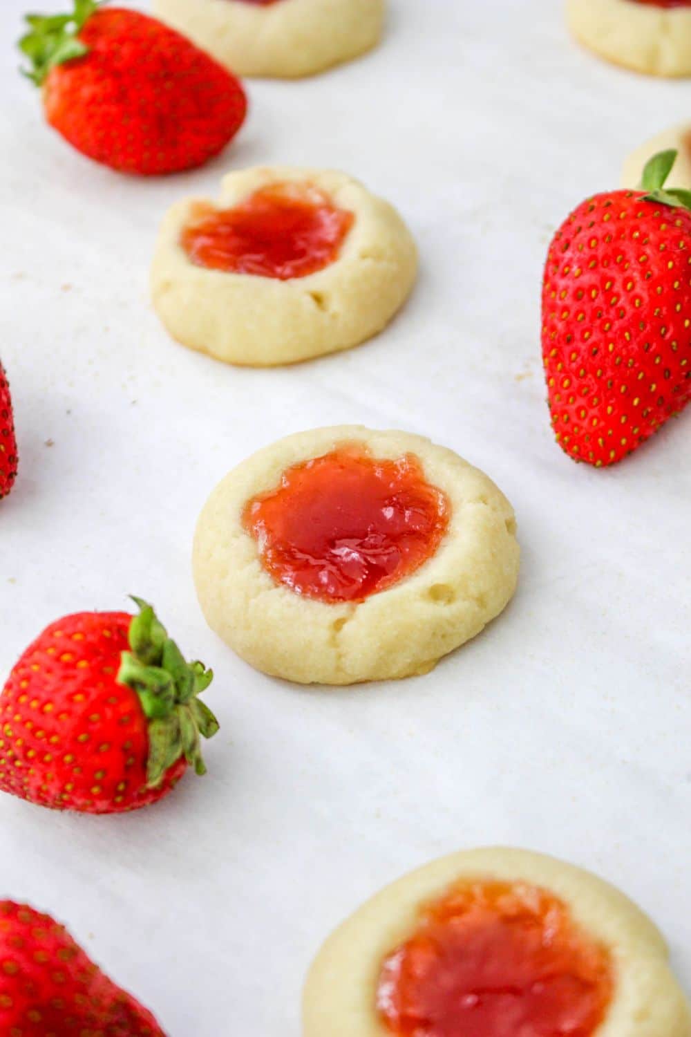 Strawberry Shortbread Cookies spread out on table berries around them