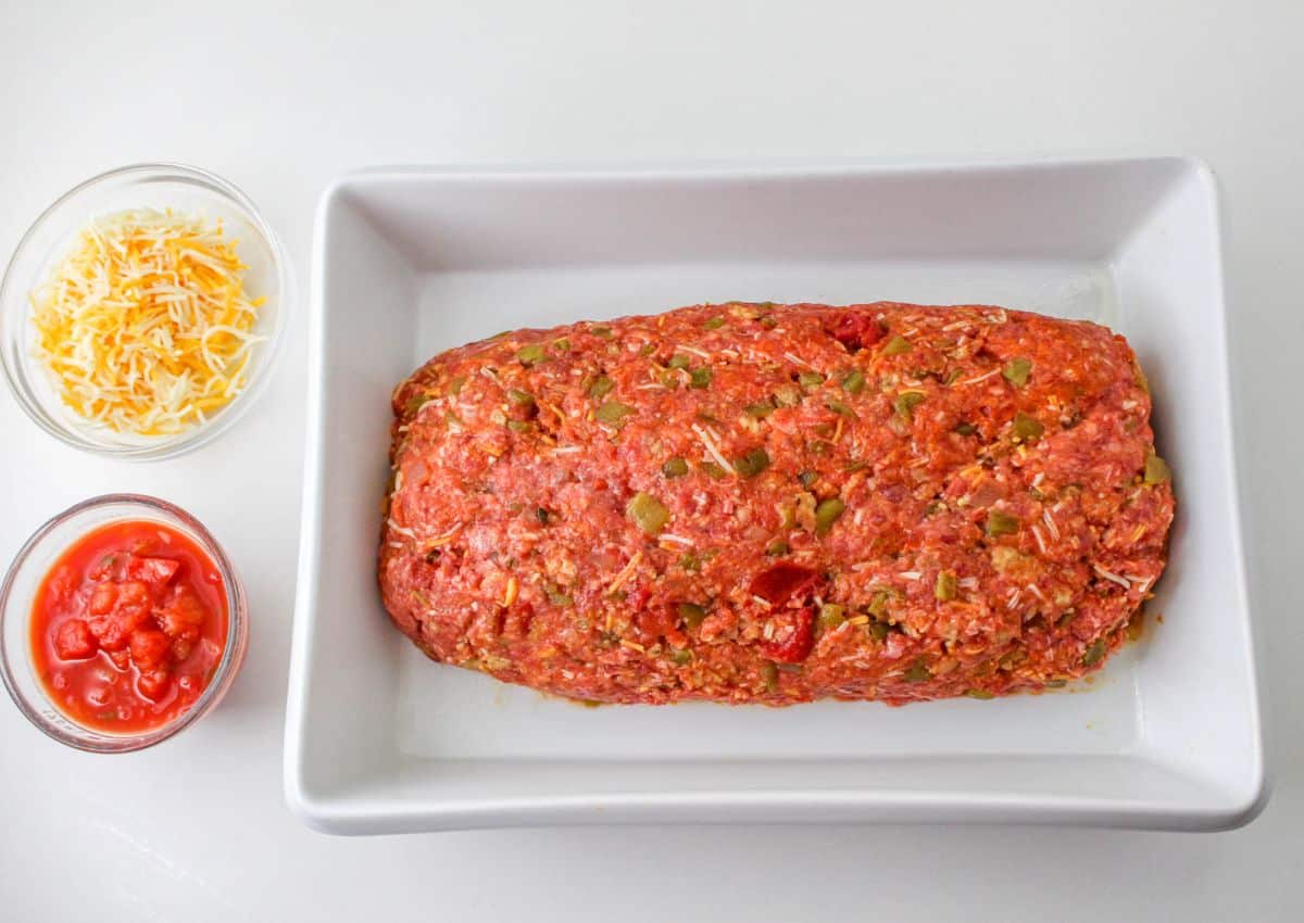 meatloaf shaped into a loaf in a baking dish.