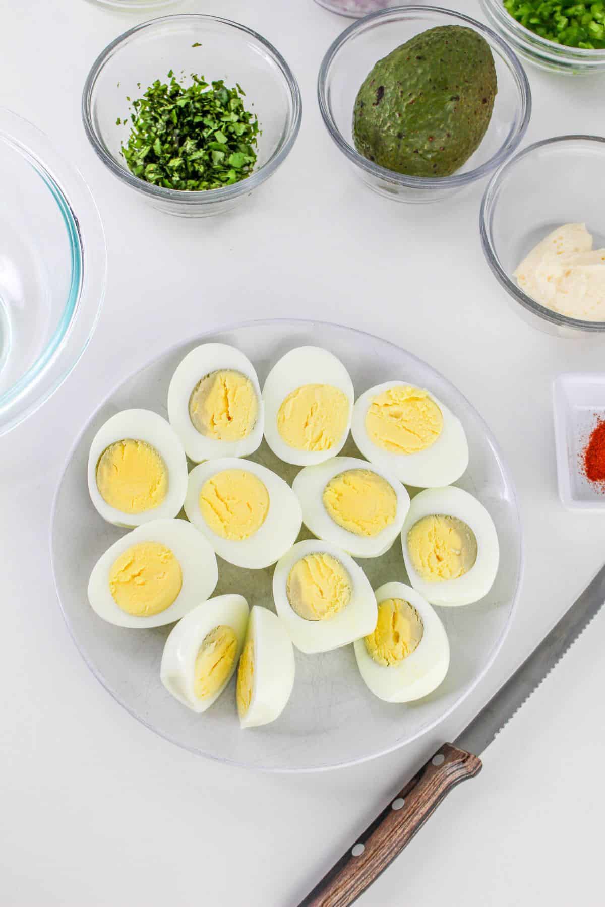 hard boiled eggs being but in half in a glass bowl.