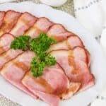 slices of ham on a platter topped with glaze.