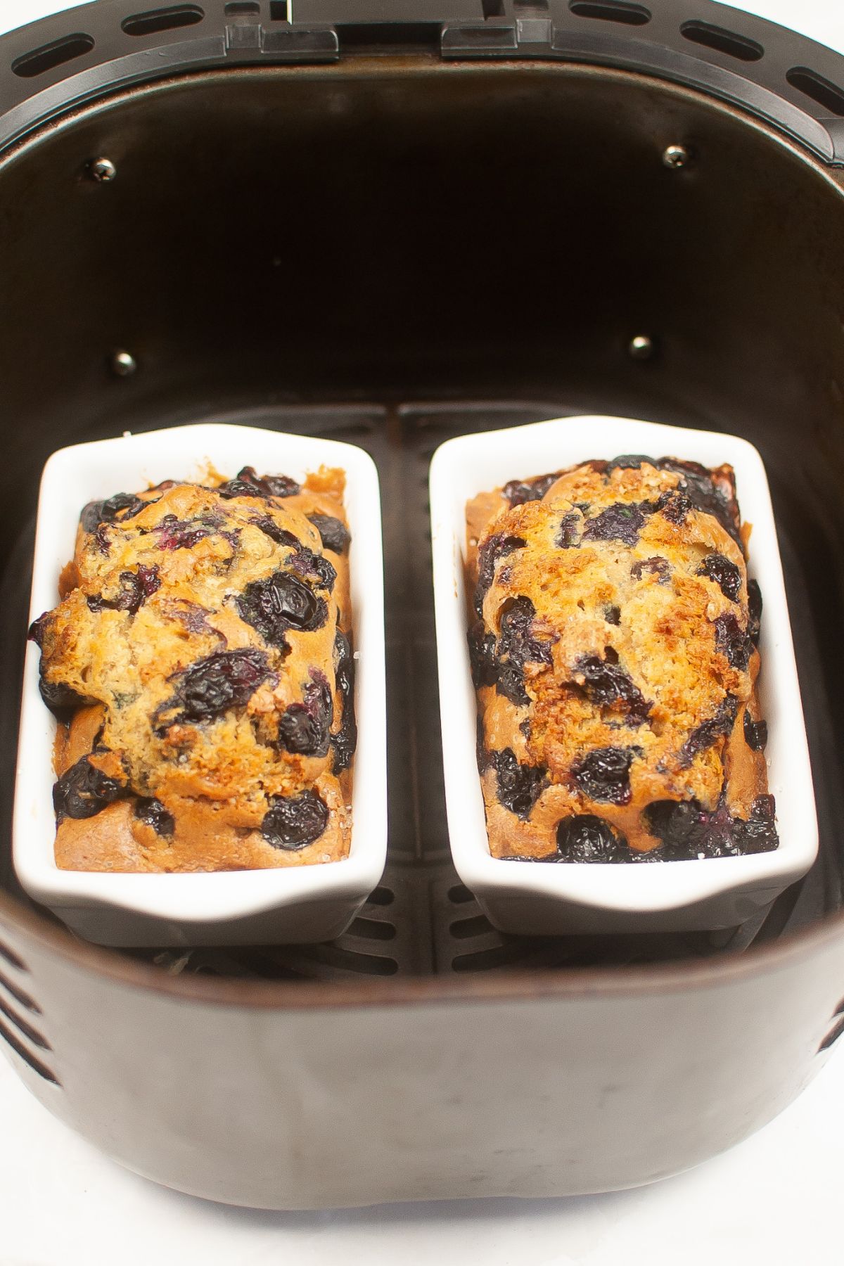two mini loaf pans with baked sourdough blueberry bread in them.