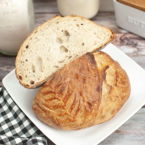 loaf of sourdough dutch oven bread cut open on a plate.