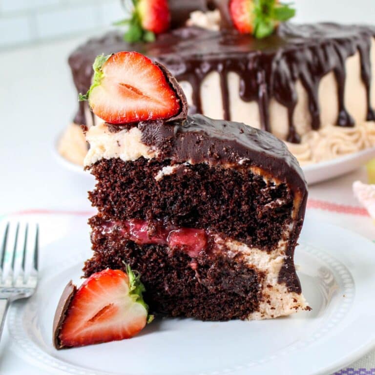 slice of chocolate cake with strawberry filling on a small plate.